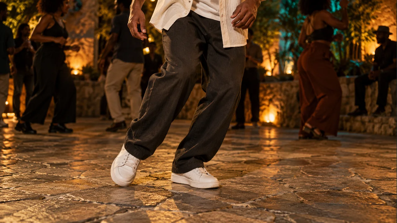 Illustrative detail of a dancer's hands and sneakers with visible contact on a stone courtyard floor